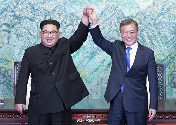 문재인 대통령과 김정은 위원장이 지난해 4월 27일 ‘판문점 선언문’에 서명한 뒤 손을 들어 보이고 있다.
