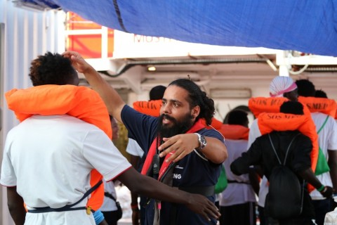국경없는의사회 직원이 몰타에 하선하기 전 몰타 군 선박으로 이동하는 생존자를 포옹하며 인사하고 있다.