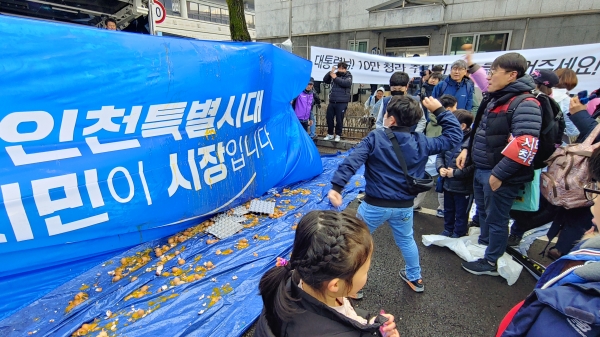 지난해 3월 청라 주민들의 청와대 앞 총집회에서 주민들이 시민이 시장입니다라는 인천시 슬로건 문구가 적힌 현수막에 달걀을 던지고 있다.